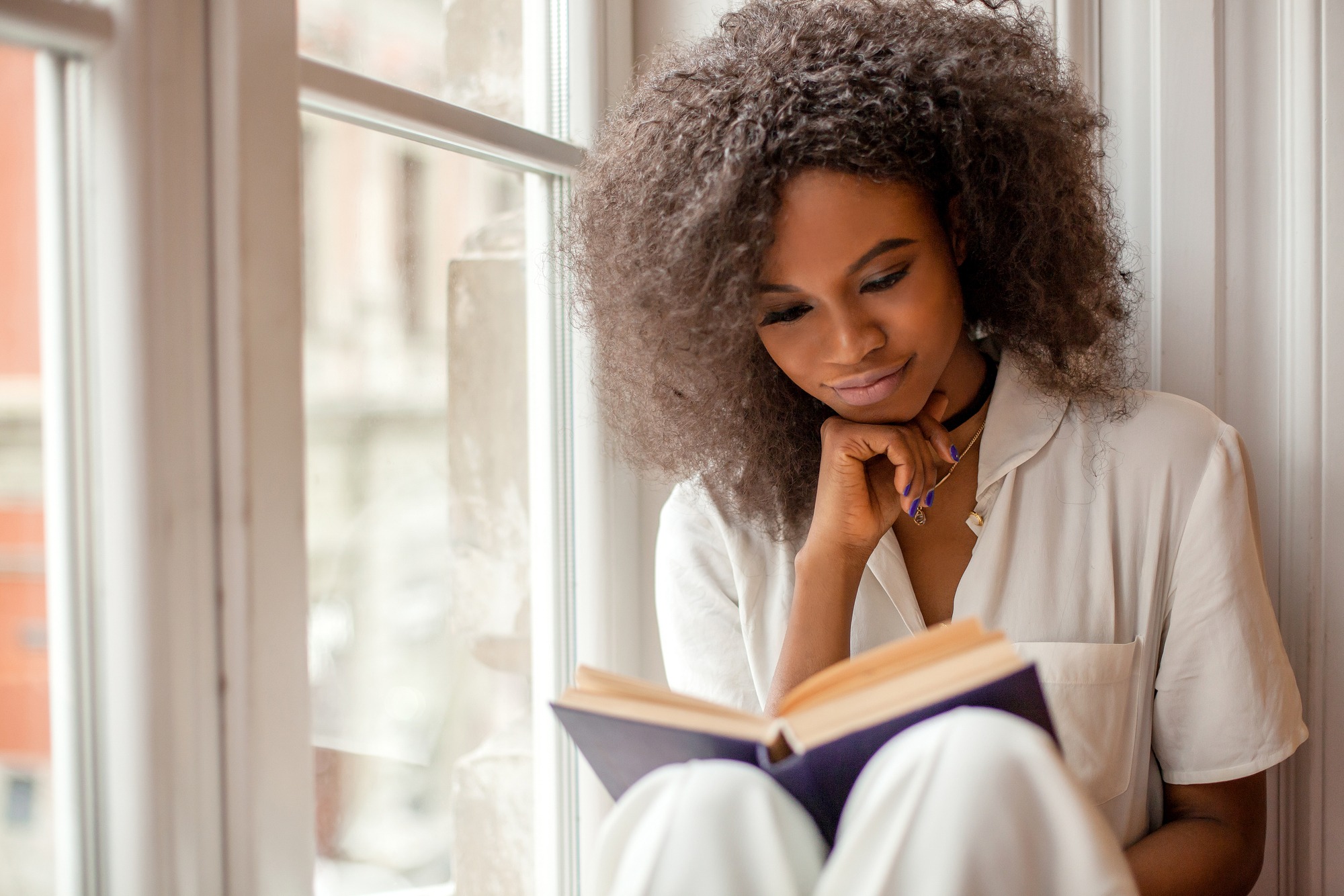 Pretty afro-american girl with reading a book
